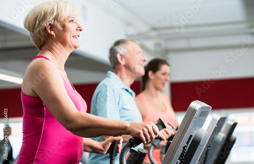 Ältere Frau trainiert am Crosstrainer im Fitnessstudio