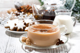 cup of spicy masala tea and Christmas cookies on white background