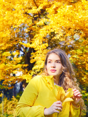 Autumn beautiful girl in the yellow forest. Woman spending holidays out of the city. People inspired by nature. Girl with yellow leaves. Autumn magic forest on the sunny day. Girl on the nature.