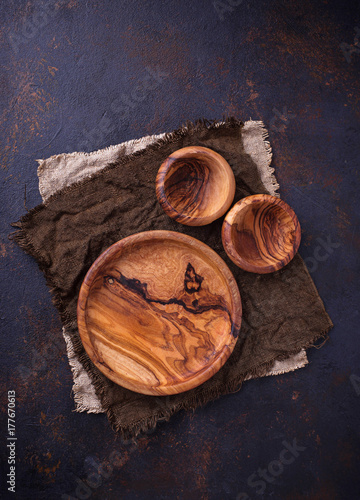 Empty wooden plate and bowls on rusty background