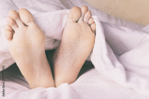 Men's legs, and alarm clock