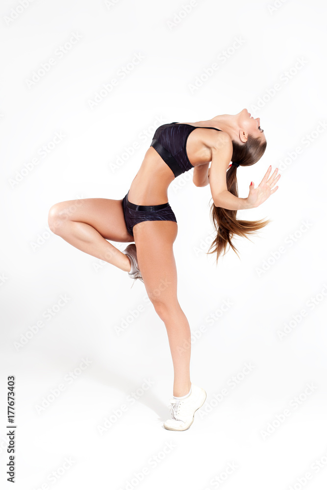 Smiling sporty girl dancing on white background Smiling sporty girl dancing on white background