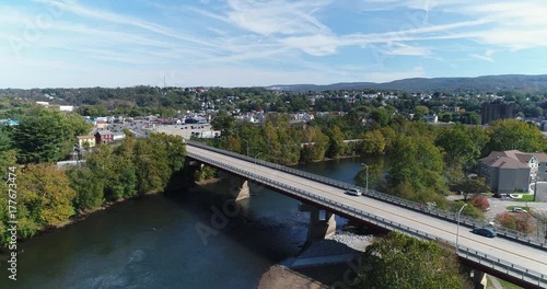 A slowly moving forward aerial shot of the small town of Connellsville, Pennsylvania while traffic travels on the Memorial Boulevard (Rt 119) bridge over the Youghiogheny River.  	 photo