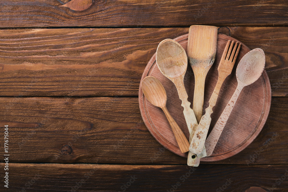 Wooden spoons, forks and shovels. On a wooden background. Top view. Free space for your text. Wooden spoons, forks and shovels. On a wooden background. Top view. Free space for your text.
