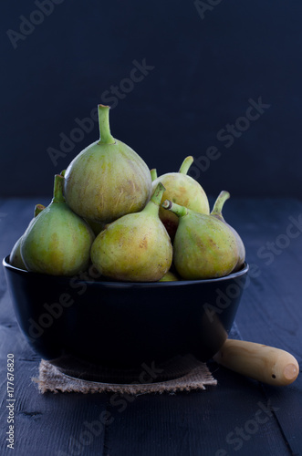 Figs in bowl on black background.