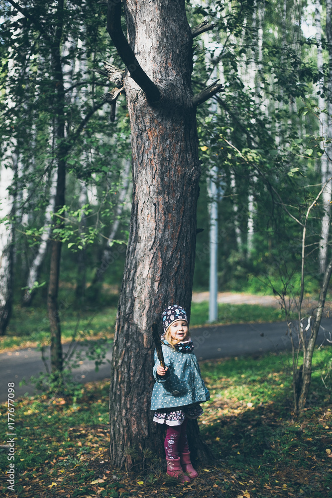 portrait of a little curly-haired girl in the woods portrait of a little curly-haired girl in the woods