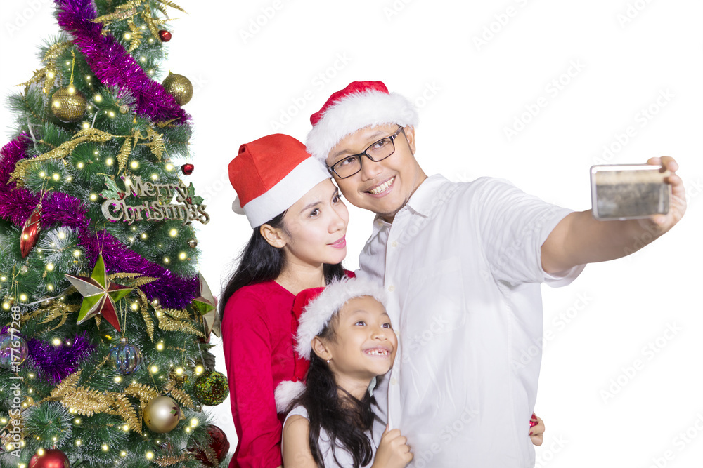 Family taking selfie picture near Christmas tree Family taking selfie picture near Christmas tree