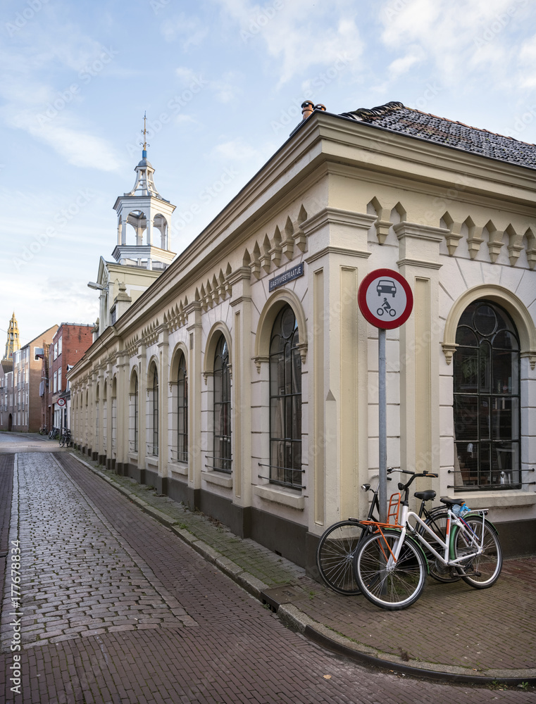 Fototapeta premium old cobblestone street and gasthuis in alley in the medieval city of groningen in the netherlands with blue sky