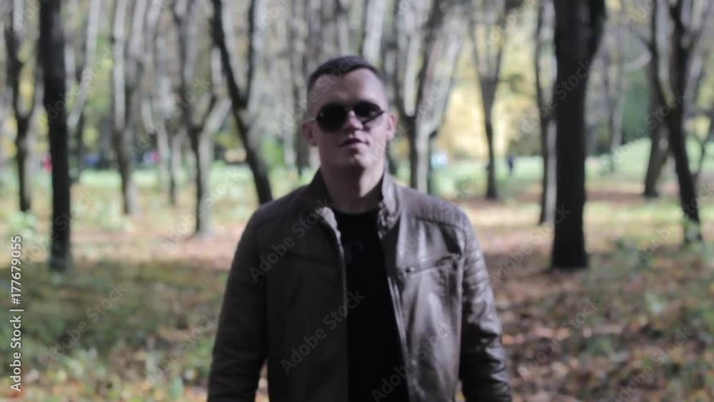 Serious confident man going and looking at camera in outdoors surrounding, close up of face. Slowmotion Serious confident man going and looking at camera in outdoors surrounding, close up of face. Slowmotion