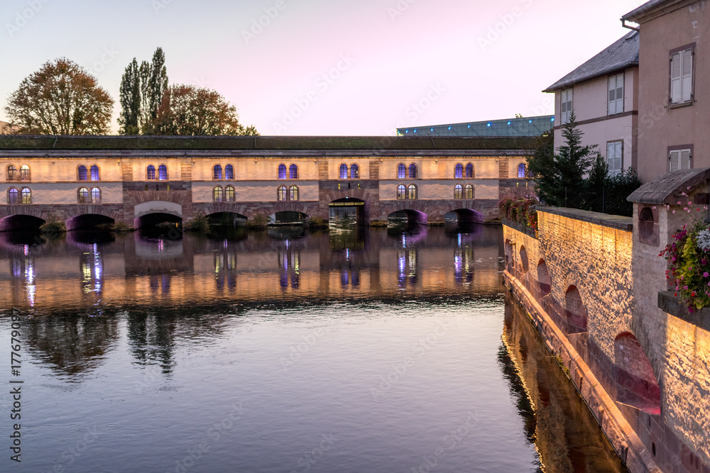 Beleuchteter Staudamm am Ill in Straßburg am Abend