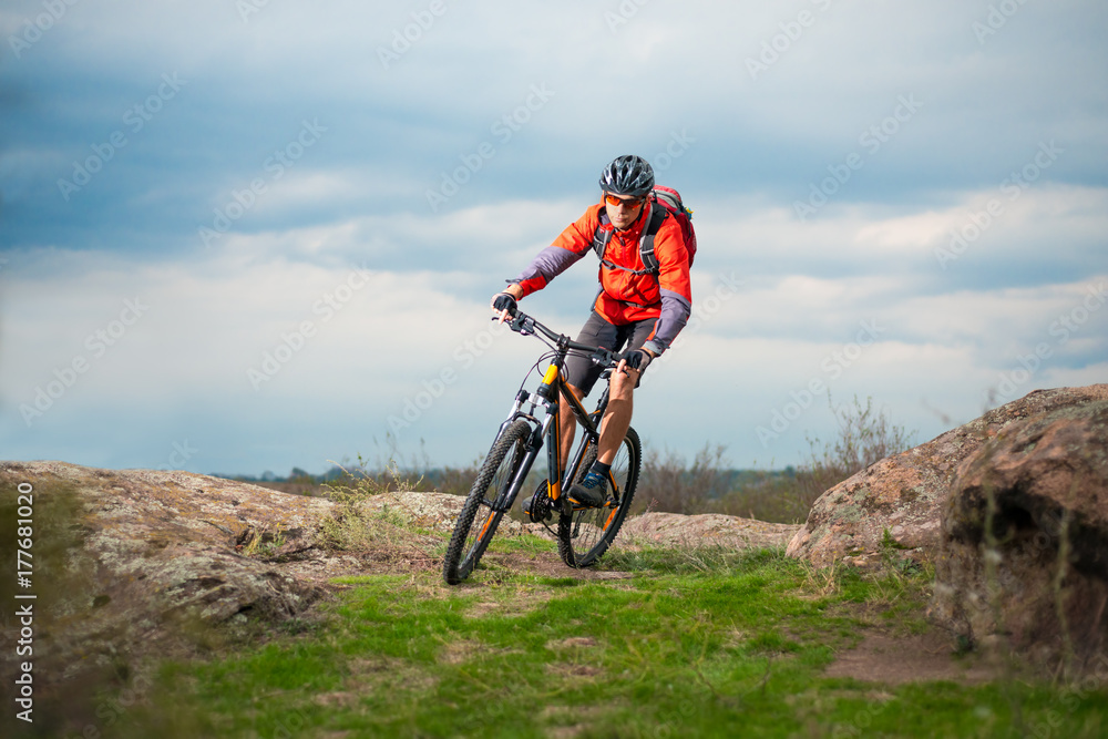 Cyclist in Red Riding Bike on the Rocky Trail. Extreme Sport and Enduro Biking Concept. Cyclist in Red Riding Bike on the Rocky Trail. Extreme Sport and Enduro Biking Concept.