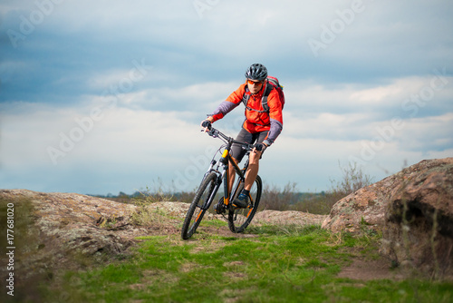 Cyclist in Red Riding Bike on the Rocky Trail. Extreme Sport and Enduro Biking Concept.