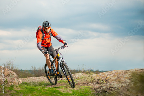 Cyclist in Red Riding Bike on the Rocky Trail. Extreme Sport and Enduro Biking Concept.