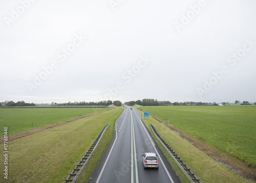 main road N46 north of groningen city between green meadows in the north of the netherlands
