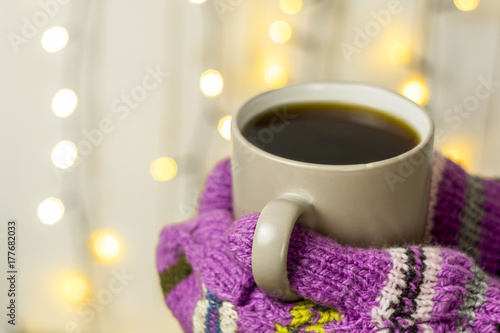 A cup of hot tea, a drink in mittens. Christmas concept. New Year's decor.