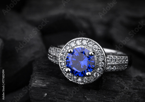 jewelry ring witht big blue sapphir on darck coal background photo
