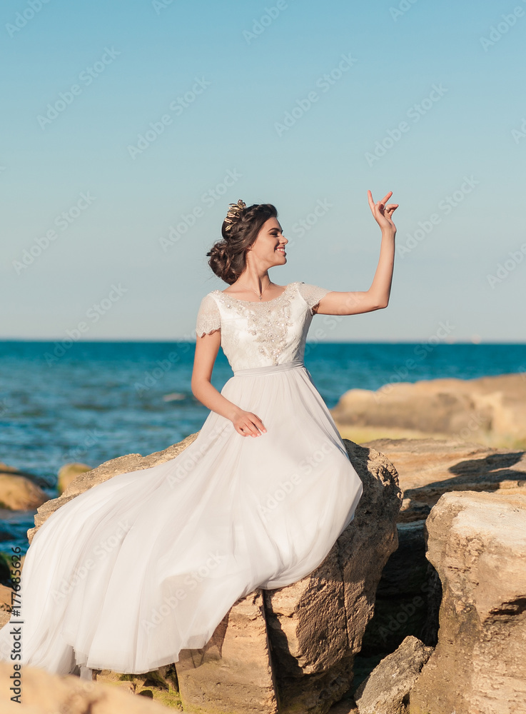 Romantic beautiful bride in luxury dress posing on the beach. Romantic beautiful bride in luxury dress posing on the beach.