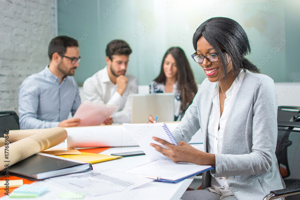 Young African-american business woman writing notes in office. Young African-american business woman writing notes in office.