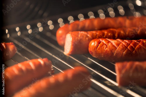 Delicious homemade baked sausage in oven with shallow depth of field. photo