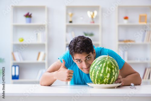 Man eating watermelon at home