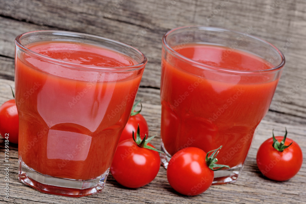 Glasses of fresh tomato juice on wooden table Glasses of fresh tomato juice on wooden table