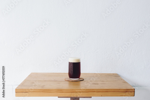 A drinking glass of cold brew dip coffee on the table with white wall background.