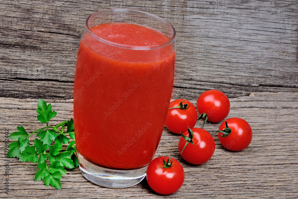 Tomato juice in a glass on rustic wooden table Tomato juice in a glass on rustic wooden table