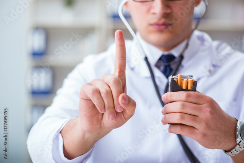 Male doctor in anti-smoking conceptwithcigarette pack