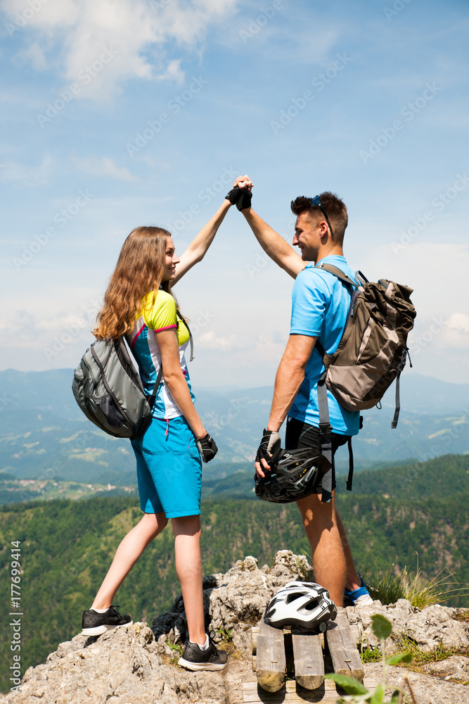 Active couple rests after biking on a mountain top