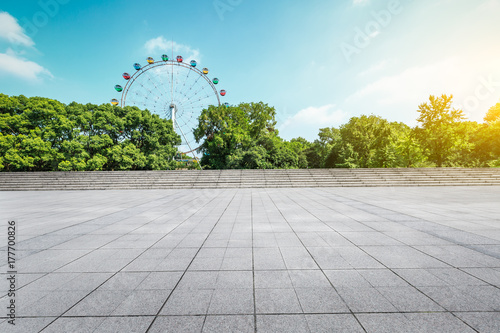 Fototapeta Naklejka Na Ścianę i Meble -  Empty floor square and playground ferris wheel in the city park