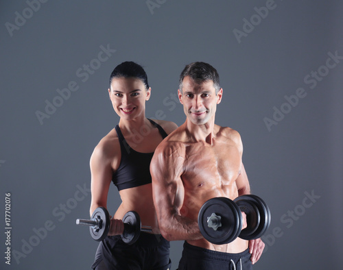 Athletic man and woman with a dumbells. Personal fitness instructor. Personal training.