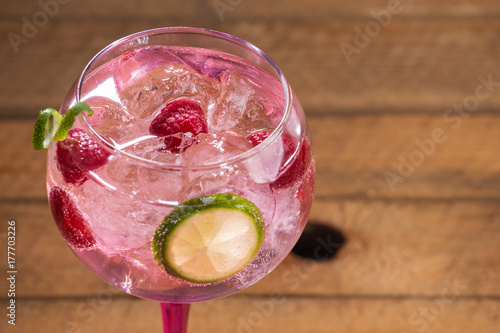 Obraz na płótnie Pink tonic gin with raspberries, wooden background w salonie