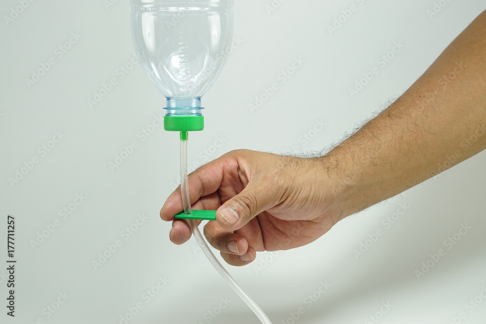 Man hand clamping detoxification tube, adapting from nasogastric tube