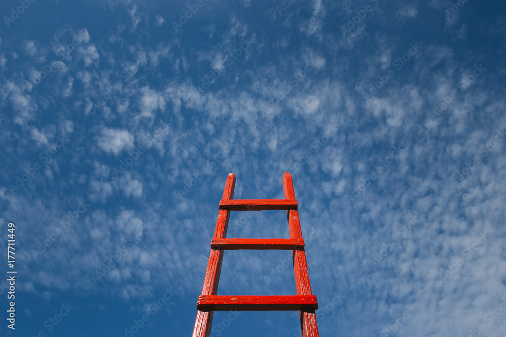 Red Staircase Rests Against Blue Sky. Development motivation Career Growth Concept - obrazy, fototapety, plakaty 