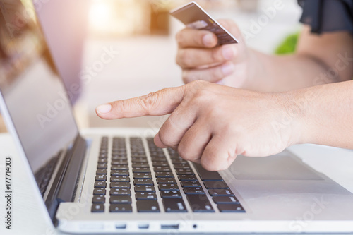 Woman hands holding credit card in front of laptop on the desk. Easy way online shopping concept