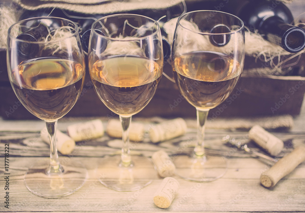 Three glasses of white wine on a wooden background. Alcoholic beverages background Three glasses of white wine on a wooden background. Alcoholic beverages background