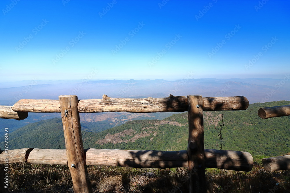 Naklejka premium Wooden fence of Kew Mae Pan nature trail with mountain scenery background at Doi Inthanon , Chaing Mai , Thailand