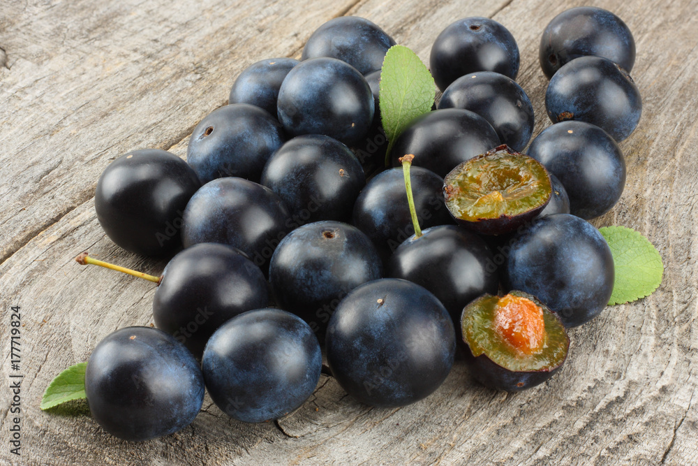 blackthorn berries with green leaf on old wooden table blackthorn berries with green leaf on old wooden table