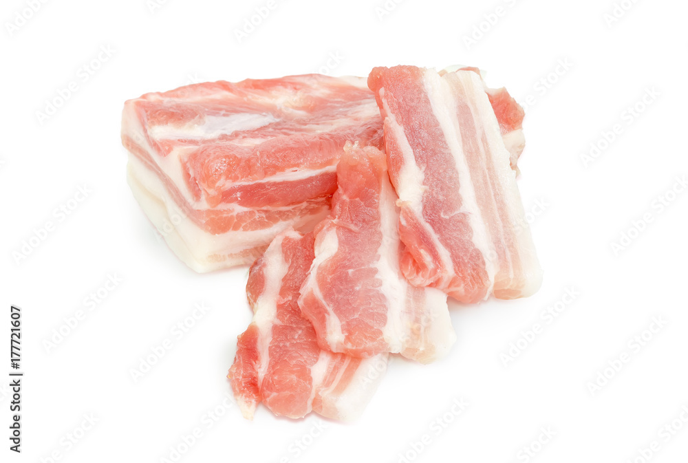 Partly sliced uncooked pork belly on a white background Partly sliced uncooked pork belly on a white background