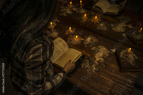 The girl holds a dark ritual reading a spell from the book of Satan.