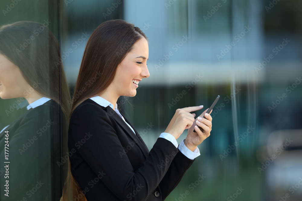Profile of an executive using a phone on the street Profile of an executive using a phone on the street
