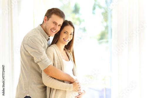 Pregnant woman and husband looking at camera
