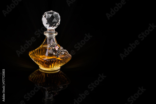 Close Up Shot Of Traditional Luxury Arabic Oud Oil Perfume In A Beautiful Handmade Clear Crystal Glass Jar Bottle and Glass Dropper Isolated On Black Background Antique Style, Text Space