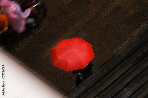 Fototapeta Naklejka Na Ścianę i Meble -  someone with red umbrella in rain on street