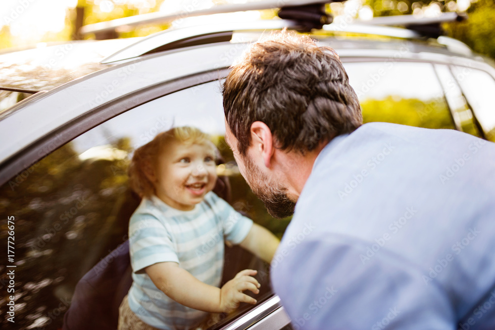 Little boy in the car, looking out of window at his father. Little boy in the car, looking out of window at his father.