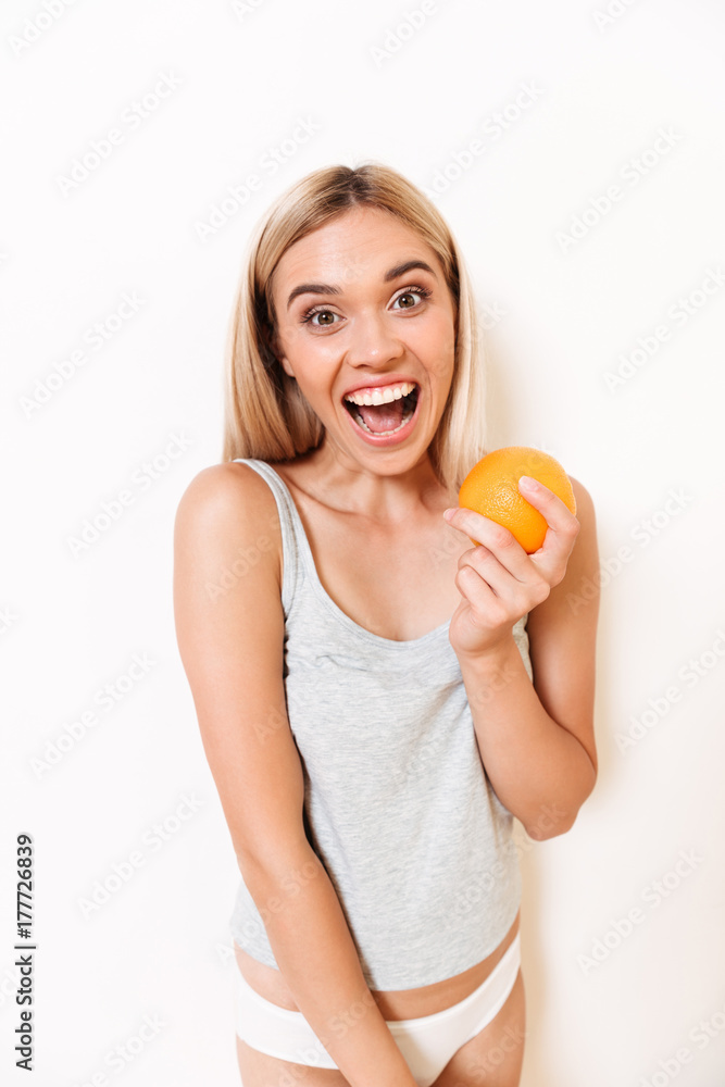 Portrait of a joyful girl in underwear holding orange fruit Portrait of a joyful girl in underwear holding orange fruit