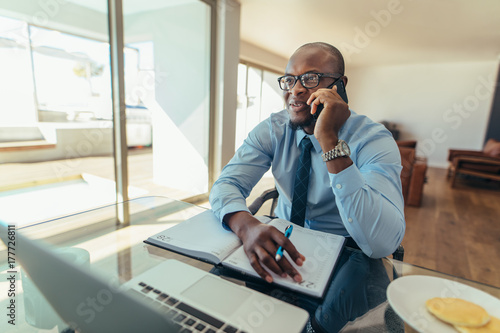 Businessman talking over mobile phone at work