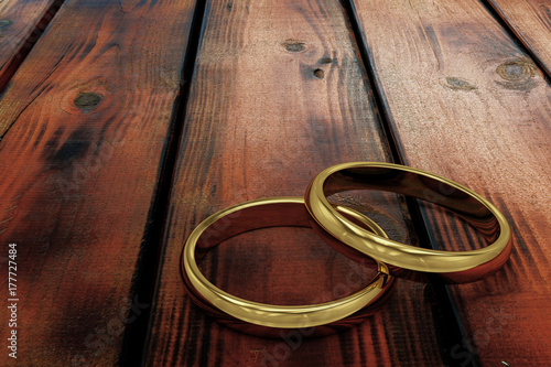 gold wedding rings on a wooden background