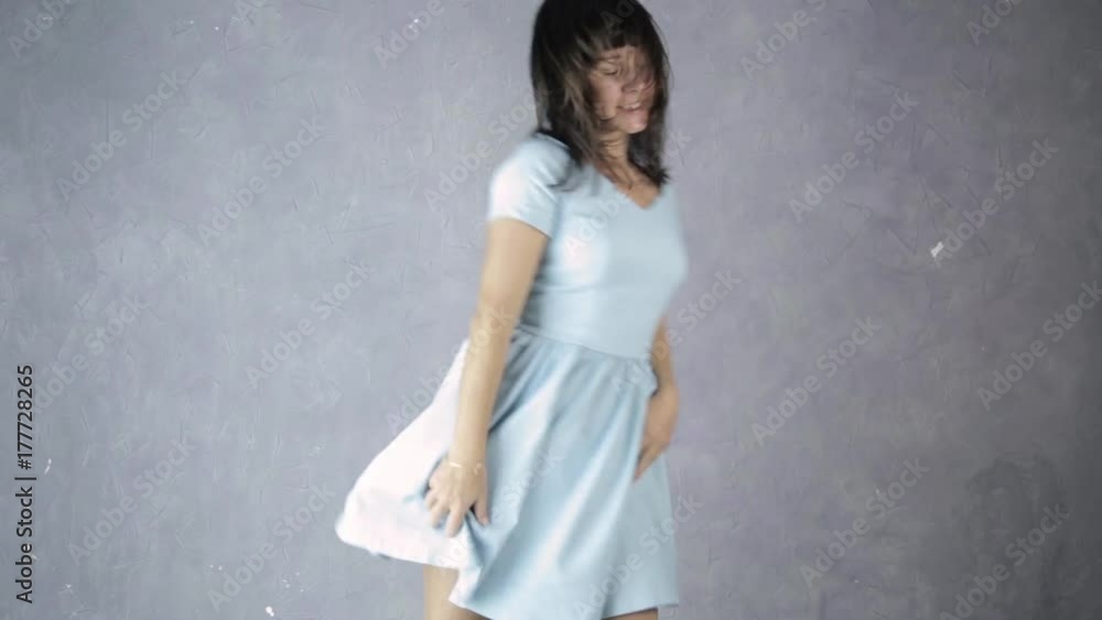 lonely young attractive woman in blue dress laughs and dances lonely young attractive woman in blue dress laughs and dances