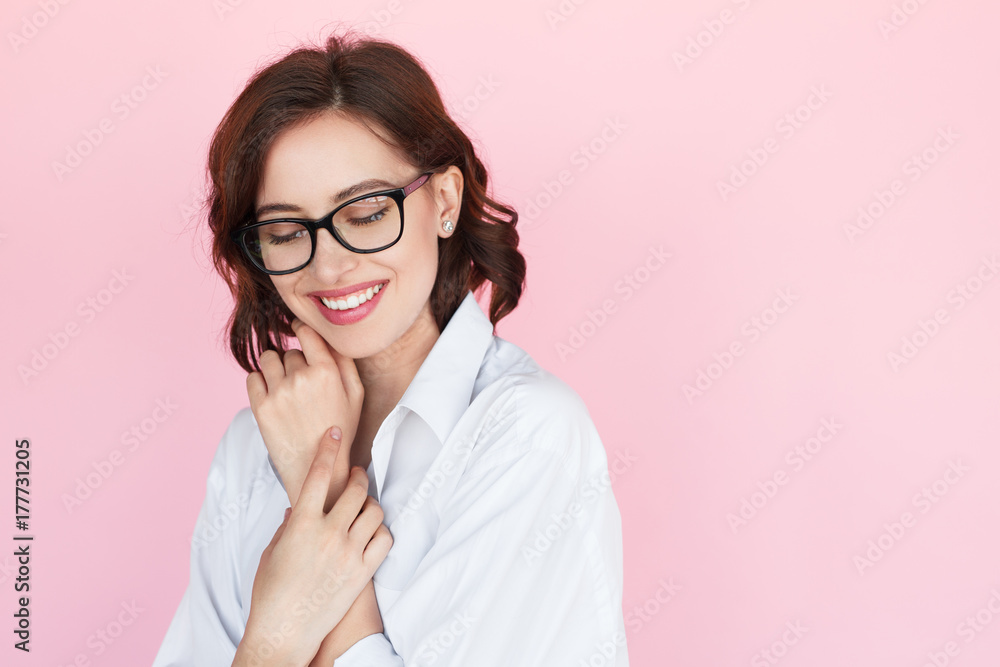 Gentle woman in eyeglasses on pink